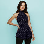 Front view of the Shopise Ines navy polka dot halter top with ruched waist and flirty peplum silhouette